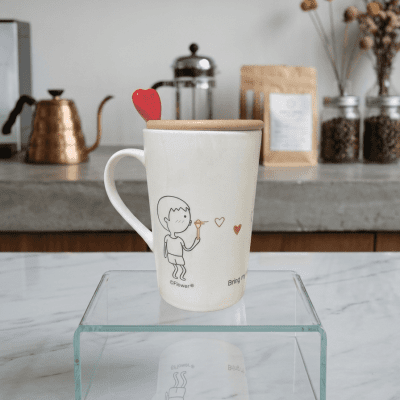 : كوب سيراميك بتصميم كرتوني مع غطاء وملعقة قلب  & Ceramic Mug with Cartoon Design, Lid, and Heart Spoon