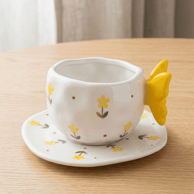 كوب سيراميك بنقوش زهور صفراء مع مقبض على شكل فراشة  & Ceramic Mug with Yellow Floral Pattern and Butterfly-Shaped Handle