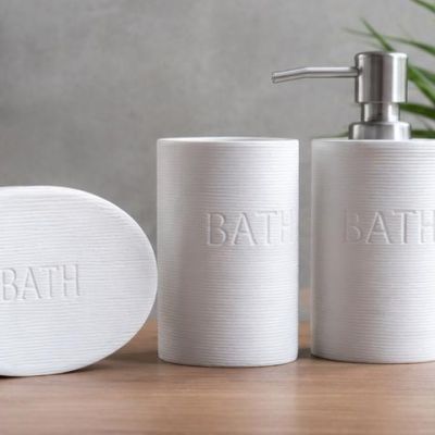 Simple and elegant bathroom accessories set featuring a modern ribbed design. Includes soap dispenser, toothbrush holders, soap dish, and tray &mdash; perfect for adding a clean and stylish touch to any bathroom decor.