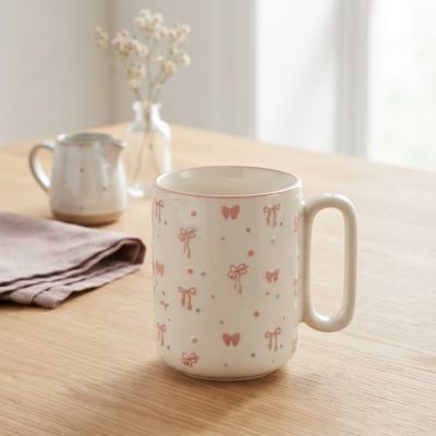 مج سيراميك ابيض  بنقشة الفيونكات ونقاط البولكا دوت.  English: Ceramic Bow and Polka Dot Print Mug.