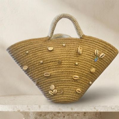 حقيبة يد قش (خوص) بتصميم هلالي مزينة بالقواقع واللؤلؤ.  &  Flared Straw Tote Bag Decorated with Seashells and Pearls.