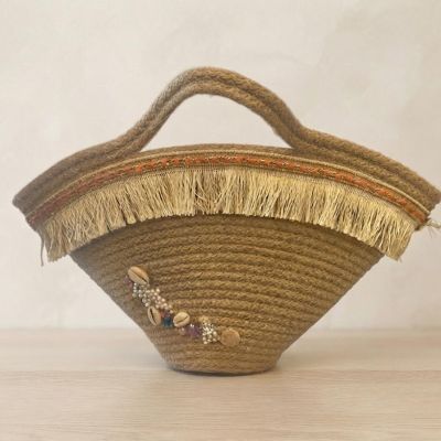 حقيبة يد قش (خوص) بتصميم هلالي مزينة بالشراشيب والقواقع.  &  Flared Straw Tote Bag Decorated with Fringes and Seashells.
