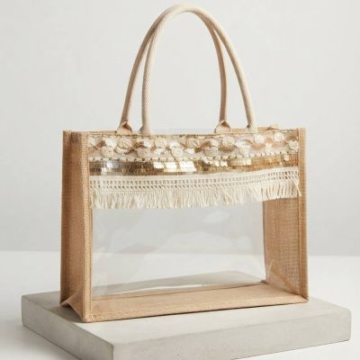 حقيبة يد بوهيمية شفافة من الخيش ومزينة بالترتر والشراشيب.&: Boho Clear PVC and Jute Tote Bag with Tassel and Sequin Details.