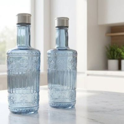 Vintage Embossed Glass Dispenser Bottle Set Elevate your kitchen counter, dining table, or vanity with this beautiful set of Vintage Embossed Glass Bottles. Combining a classic antique aesthetic with modern functionality, these tinted blue glass bottles a