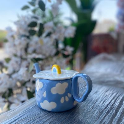 Tiny Tea Clouds Tea Pot featuring a sky-blue base with white cloud patterns and a sunshine-yellow rainbow knob on the lid