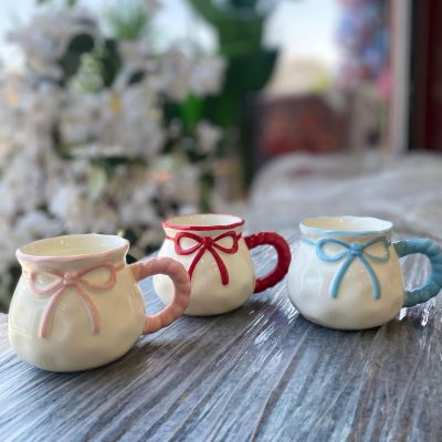 ceramic mugs designed with a 3D relief bow and a matching twisted handle