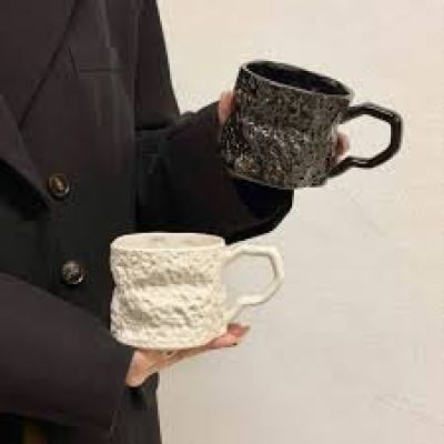 unbranded black, heat-resistant ceramic or porcelain mugs featuring a unique, textured, irregular rock-like design and an angular handle