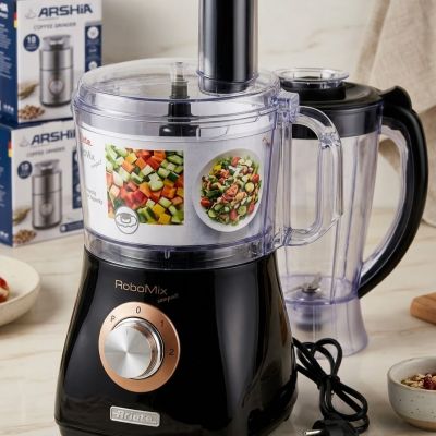 محضر طعام أريتي روبوميكس المدمج (RoboMix Compact): ذكاء الأداء في تصميم موفر للمساحة، يجمع بين اللون الأسود اللامع واللمسات النحاسية الفاخرة. يأتي مع دورق خلاط مستقل ليمنحكِ سرعة وكفاءة فائقة في الفرم، التقطيع، والخلط، مما يجعله القطعة العملية الأجمل لمطب